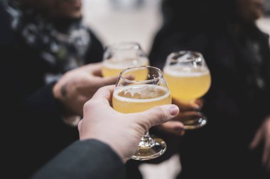 İnsanlar bir partide dışarıda bira içerek kadeh kaldırıyor.