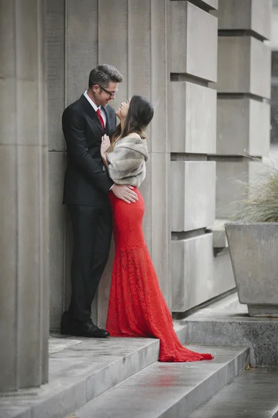 Couple embracing on the steps of a building. — Stock Photo, Image