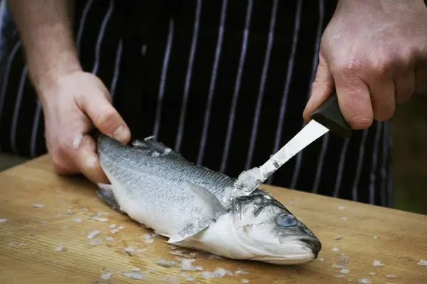 Chef scalare un pesce fresco . — Foto Stock