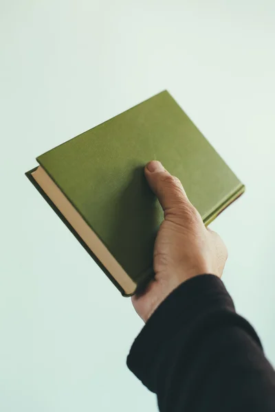 Рука держит зеленую книгу — стоковое фото