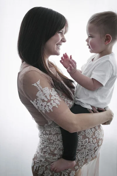 Беременная женщина держит сына — стоковое фото