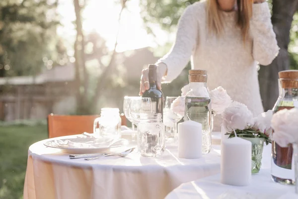 Woman setting a table in a garden — Stock Photo, Image