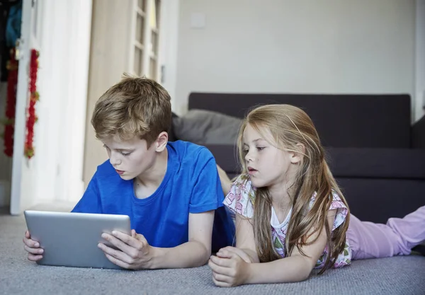 Dos niños compartiendo una tableta digital — Foto de Stock