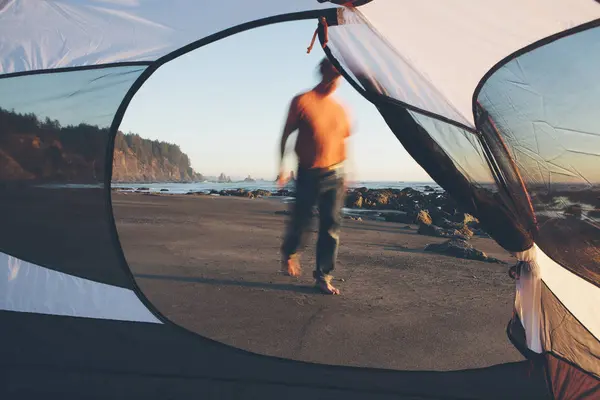 Man gå på stranden i skymningen — Stockfoto