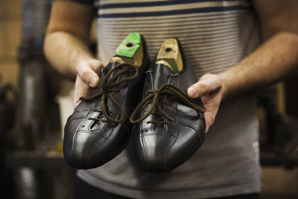 Человек, держащий пару обуви — стоковое фото