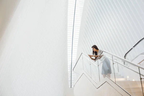 Vrouw op trappen leunend op de balustrade — Stockfoto