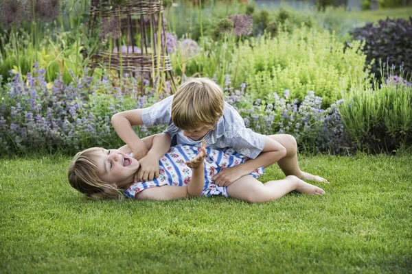 Garoto e menina sorridente em um jardim — Fotografia de Stock