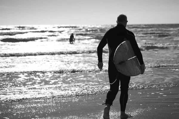 Hombre llevando tabla de surf . — Foto de Stock