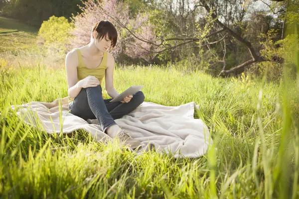 Mujer Joven Sentada Campo Cubierto Hierba Manta Uso Tableta Digital — Foto de Stock