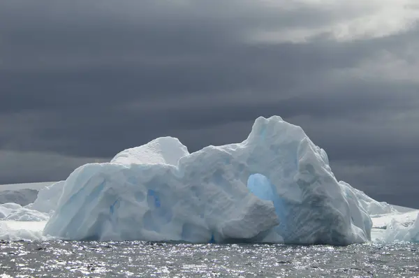 嵐の灰色の空の下で南の海の水の上の氷山 — ストック写真