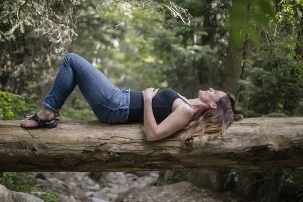 Жінка Лежить Спині Падаючому Стовбурі Дерева Лісі — стокове фото