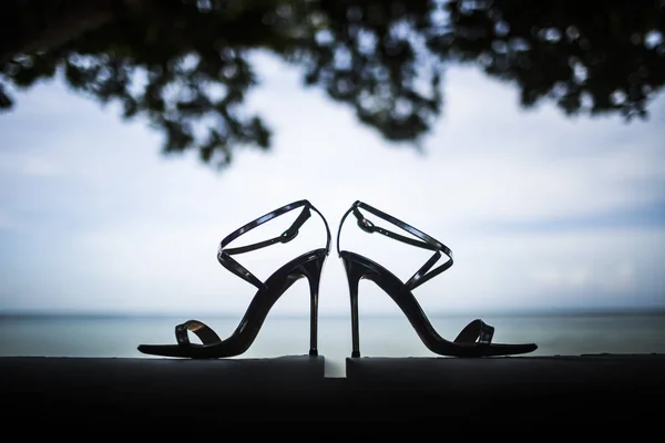 Close Pair Shiny Stiletto Sandals Tree Foliage Ocean Background — Stock Photo, Image