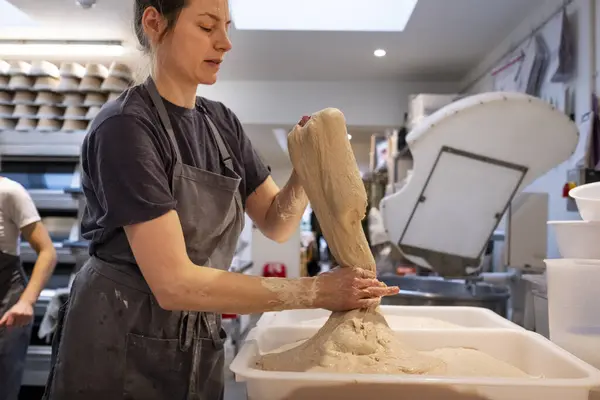 Frau Mit Schürze Steht Einer Bäckerei Und Arbeitet Mit Sauerteig — Stockfoto