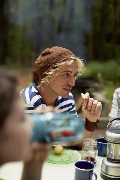 Uomo seduto a un tavolo da picnic nel bosco . — Foto stock