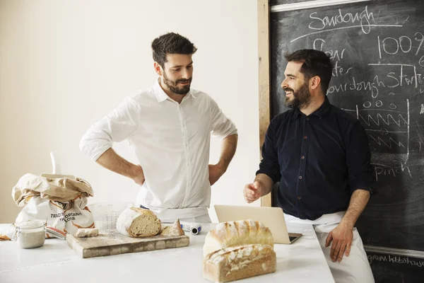 Panaderos utilizando un ordenador portátil - foto de stock