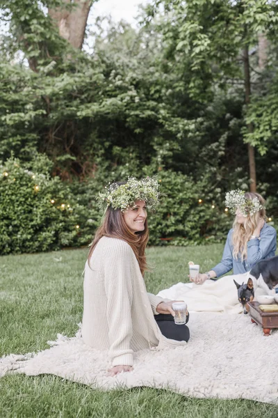 Lächelnde Frauen mit einem Blumenkranz — Stockfoto