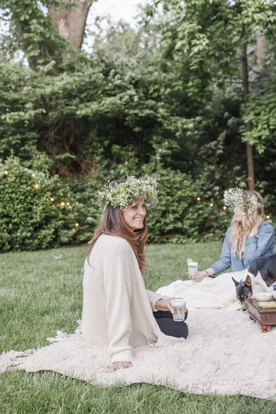 Mulheres sorridentes com coroas de flores — Fotografia de Stock