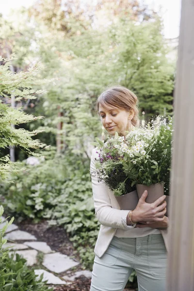 Femme portant un bouquet de fleurs blanches . — Photo de stock