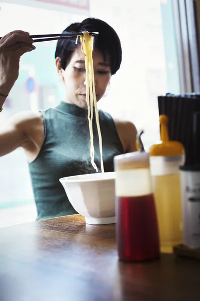 Donna mangiare noodles ramen — Foto stock