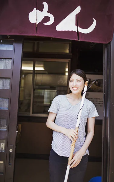Femme debout près de la porte du magasin de nouilles — Photo de stock