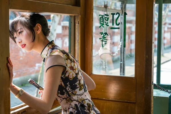 Local young Chinese woman in vintage Asian dress in old retro tram, Shanghai, China — Stock Photo