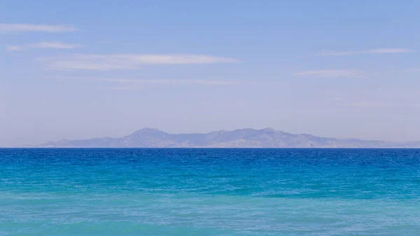 Paisaje tranquilo. Superficie del mar y montañas en el fondo — Foto de Stock