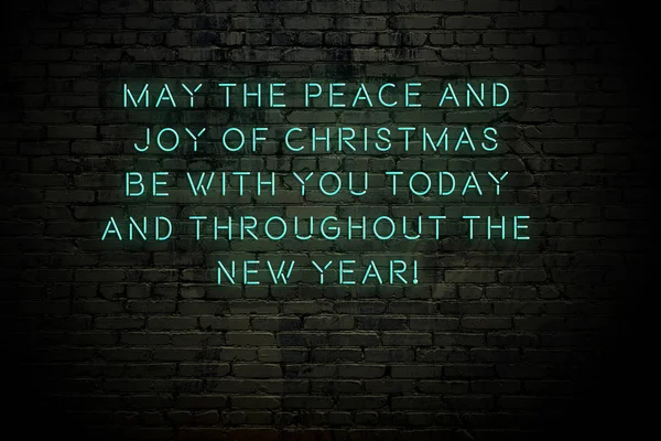 Неоновий напис різдвяних і новорічних привітань на цегляній стіні — стокове фото