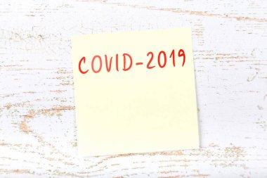 Yellow sticky note with reminder of coronavirus danger