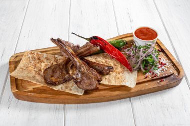 Sebzeli ızgara koyun pirzolası ve ahşap masada kırmızı sos. 