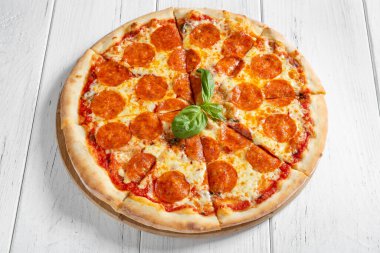 Salamlı pizza ve beyaz ahşap masada mozzarella.