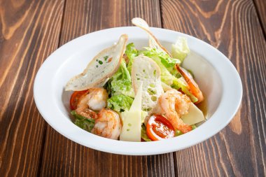 Tahta masadaki karidesli sezar salatası.