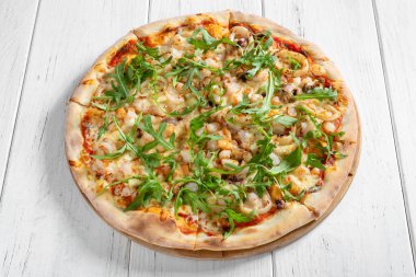 Şempanzeli taze İtalyan pizzası ve ahşap masa üzerinde kalamar.