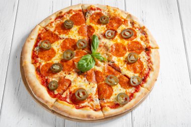 Salamlı pizza, mozzarella ve beyaz ahşap masada biberli biber.