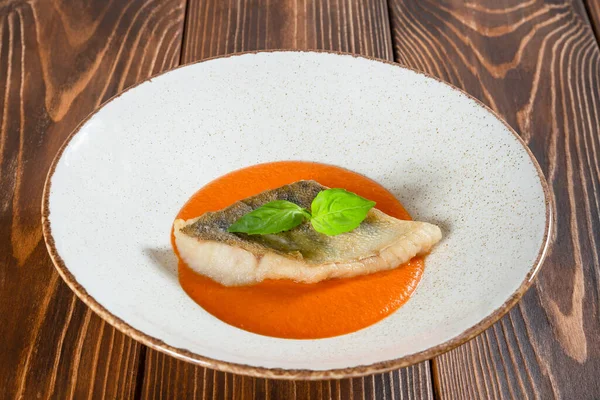 Тарелка рыбного филе с тыквенным соусом на деревянном столе — стоковое фото