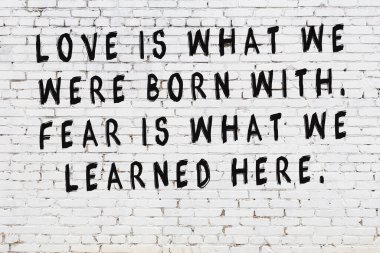 Beyaz tuğla duvar arkaplanına siyah düşünceli bir yazı.