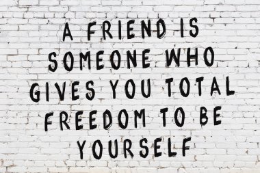 Beyaz tuğla duvar arkaplanına siyah düşünceli bir yazı.