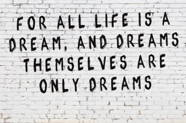 Beyaz tuğla duvar arkaplanına siyah düşünceli bir yazı.