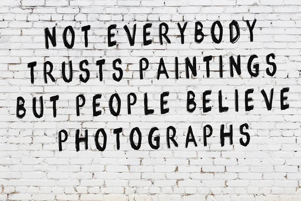 White brick wall with painted black inscription of wise quote — Stock Photo, Image