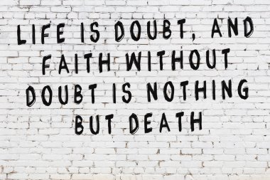 Beyaz tuğla duvar arkaplanına siyah düşünceli bir yazı.