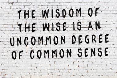 Bilgece alıntıların yazılı olduğu siyah boyanmış beyaz tuğla duvar