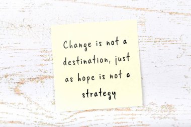 Ahşap duvardaki sarı yapışkan notta bilgece bir alıntı var.