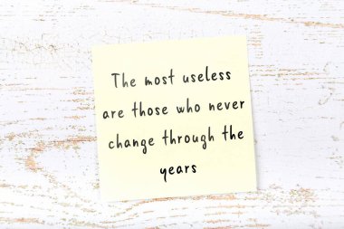 Ahşap duvardaki sarı yapışkan notta bilgece bir alıntı var.