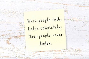 Ahşap duvardaki sarı yapışkan notta bilgece bir alıntı var.