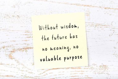 Ahşap duvardaki sarı yapışkan notta bilgece bir alıntı var.