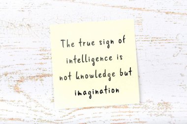 Ahşap duvardaki sarı yapışkan notta bilgece bir alıntı var.