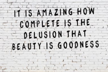 Beyaz tuğla duvar arkaplanına siyah düşünceli bir yazı.