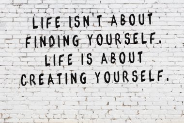 Bilgece alıntıların yazılı olduğu siyah boyanmış beyaz tuğla duvar