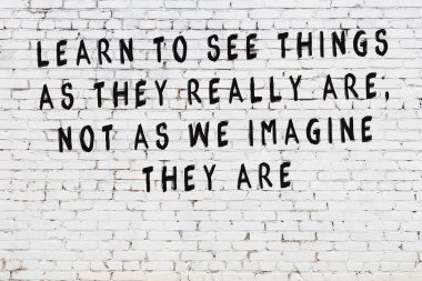 Bilgece alıntıların yazılı olduğu siyah boyanmış beyaz tuğla duvar