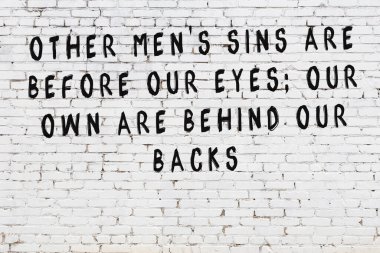 Beyaz tuğla duvar arkaplanına siyah düşünceli bir yazı.