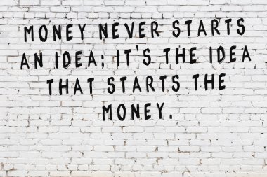 Beyaz tuğla duvara zekice alıntılar yazılı siyah bir yazı.